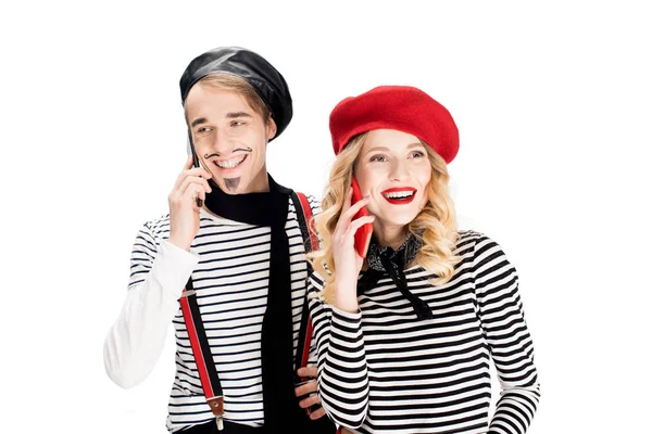 Felice coppia in berretti parlando su smartphone isolati su bianco — Foto stock