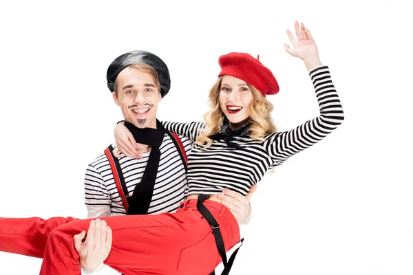 Alegre hombre sosteniendo en brazos sonriente mujer aislado en blanco - foto de stock