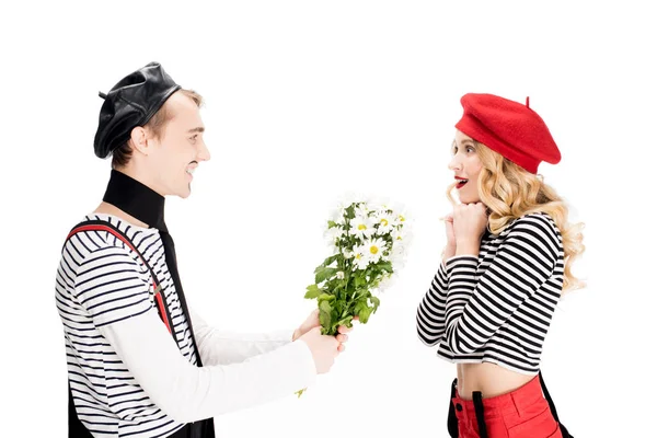 Francese uomo dando fiori alla donna attraente in berretto rosso isolato su bianco — Foto stock