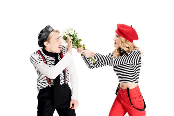 Homme et femme en béret rouge se battant avec des fleurs isolées sur blanc — Photo de stock