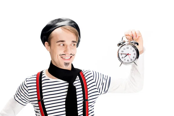 Веселий французький чоловік дивиться на будильник і посміхається ізольовано на білому — стокове фото