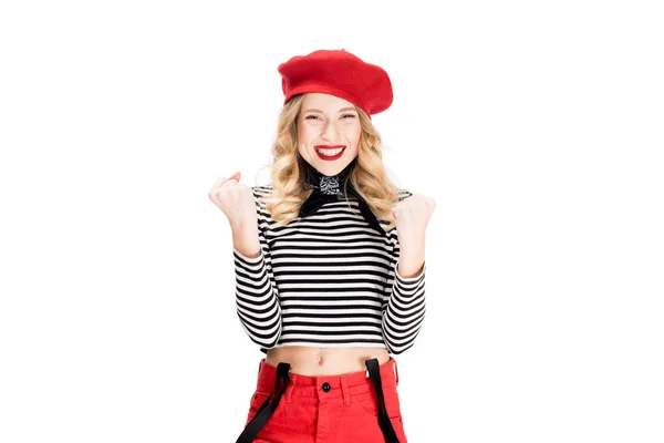 Alegre mujer en boina roja sonriendo mientras celebrando ganar aislado en blanco - foto de stock