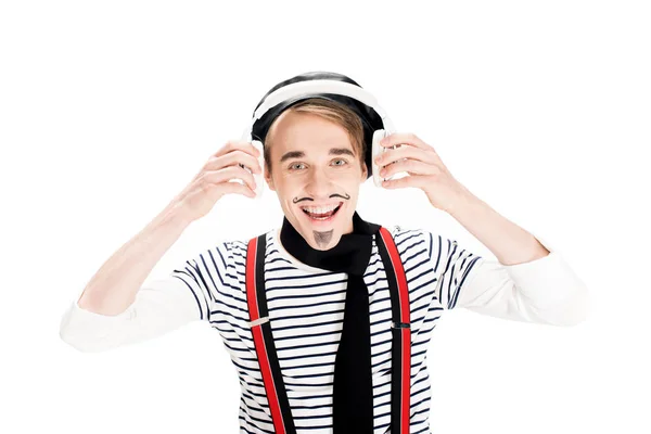 Uomo sorridente con baffi che ascolta musica in cuffie isolate su bianco — Foto stock