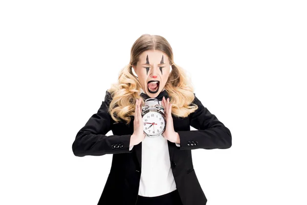 Payaso femenino sosteniendo el despertador y gritando aislado en blanco - foto de stock