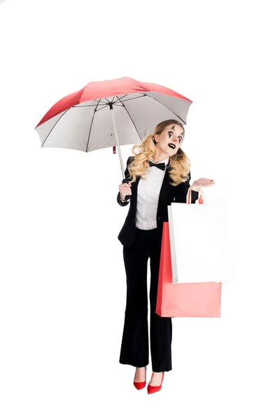 Clown donna bionda che tiene borse della spesa e ombrello isolato su bianco — Foto stock