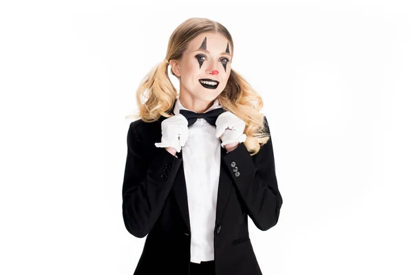 Alegre rubia payaso de pie en traje y tocando lazo aislado en blanco - foto de stock