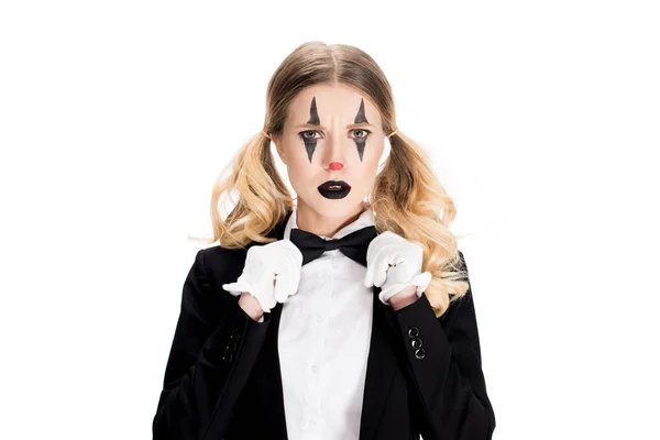 Sad female clown standing in suit and touching bow tie isolated on white — Stock Photo