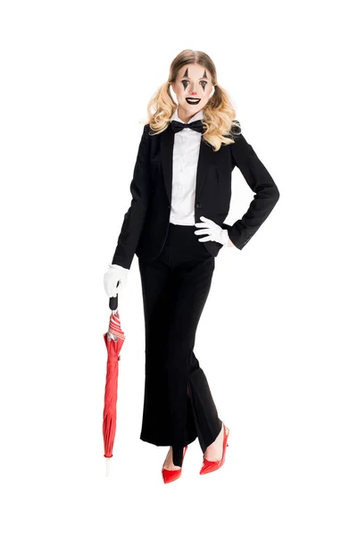 Счастливая женщина-клоун держит зонтик, стоя в костюме, изолированном на белом — стоковое фото