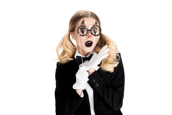 Impactado payaso rubio sosteniendo gafas falsas en palo aislado en blanco - foto de stock