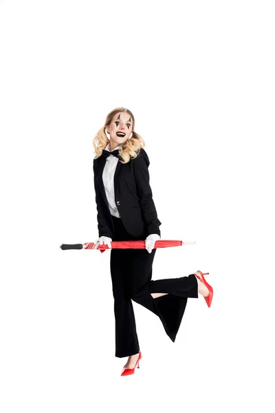 Cheerful female clown holding umbrella while standing in suit isolated on white — Stock Photo