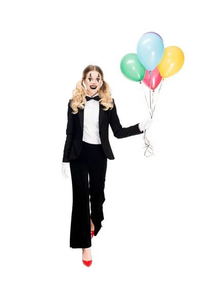 Heureux clown femelle en costume tenant des ballons et souriant isolé sur blanc — Photo de stock