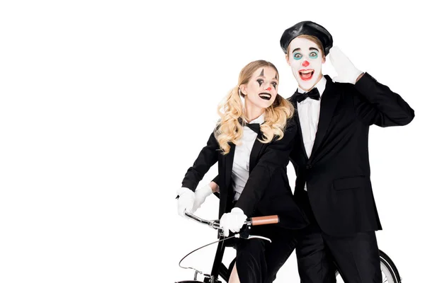 Cheerful couple of clowns riding bicycle isolated on white — Stock Photo