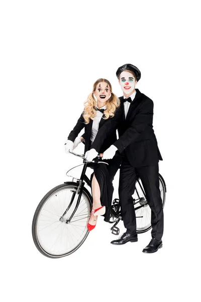 Smiling couple of clowns riding bicycle isolated on white — Stock Photo