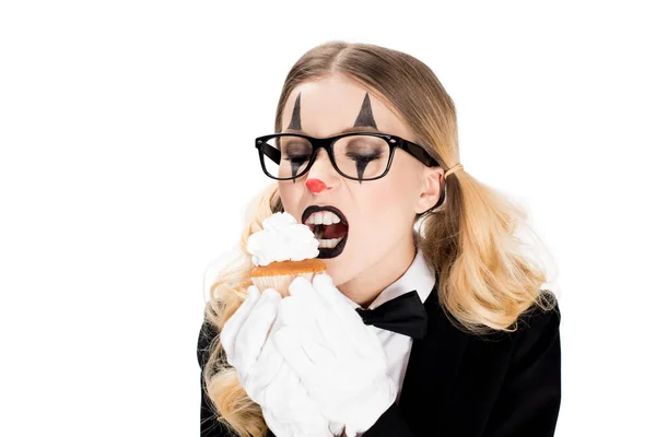 Жіночий клоун в окулярах дивиться на смачний кекс ізольовано на білому — стокове фото