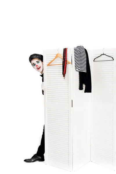 Palhaço alegre em boina preta olhando para fora da porta do camarim isolado no branco — Fotografia de Stock