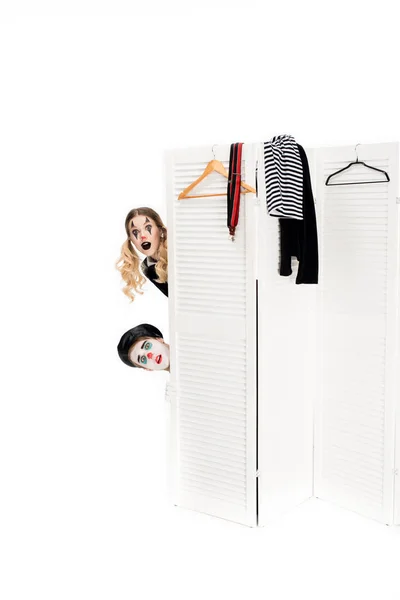 Surprised clowns looking out from dressing room door isolated on white — Stock Photo