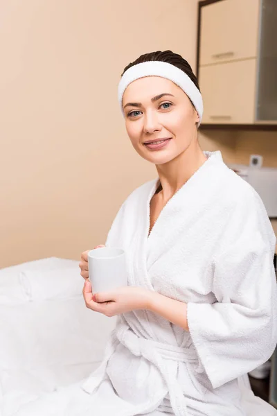 Woman sitting and holding cup in hand at beauty salon — Stock Photo