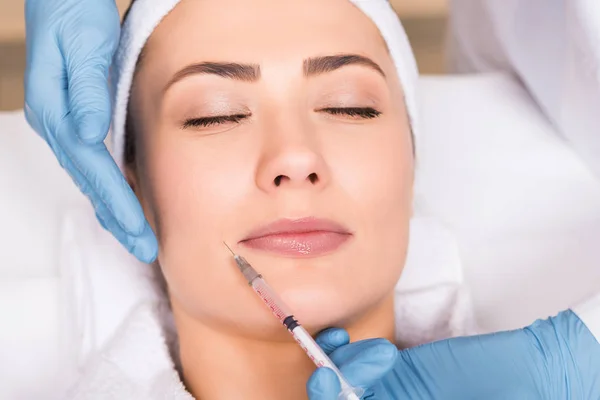 Top view of beautician making injection on woman face at beauty salon — Stock Photo