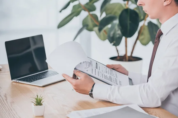 Cropped view of businessman reading compensation claim at workplace — Stock Photo