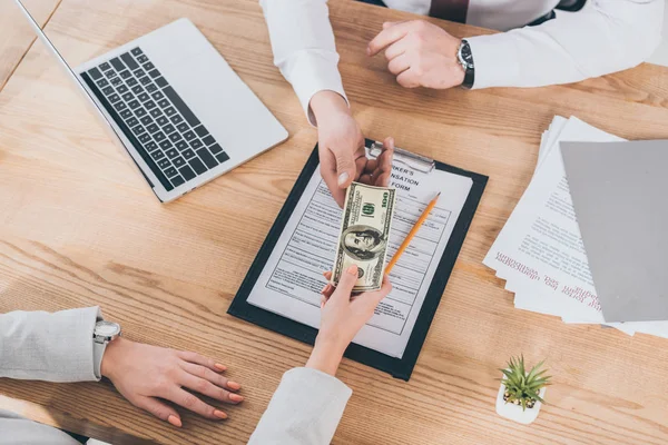 Visión parcial de la mujer de negocios dando dinero al hombre de negocios, concepto de compensación - foto de stock