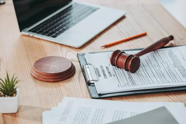 Clipboard with compensation claim form and gavel lying over on the office desk, compensation concept — Stock Photo