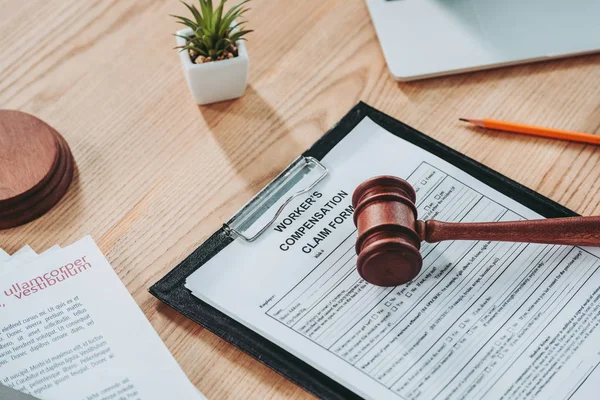 Clipboard with compensation claim form and gavel on office desk — Stock Photo