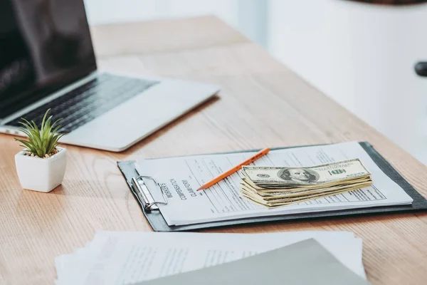 Clipboard with compensation claim form and money on office desk — Stock Photo