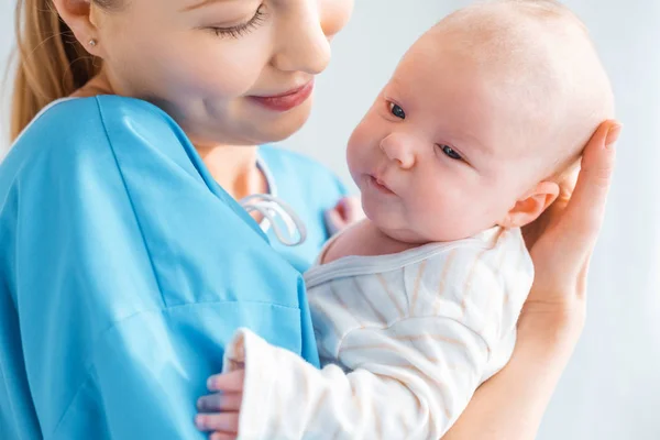 Plan recadré de jeune mère heureuse portant bébé adorable à l'hôpital — Photo de stock