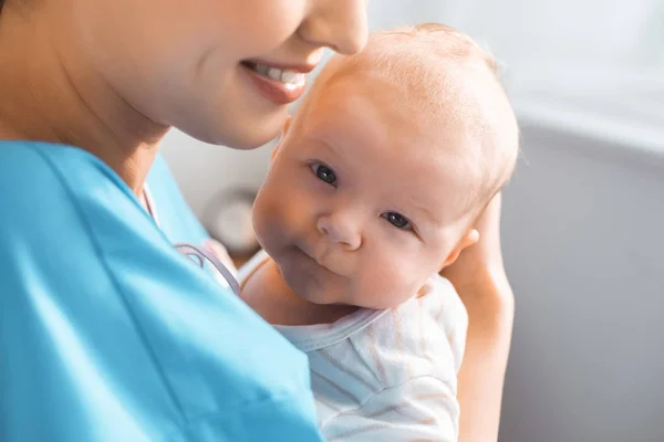 Recortado disparo de feliz joven madre llevando adorable bebé en la habitación del hospital - foto de stock