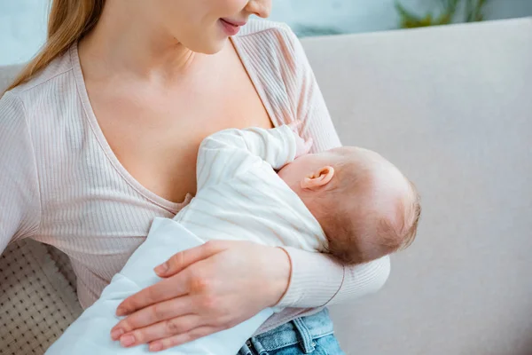 Colpo ritagliato di giovane donna che allatta figlia neonata a casa — Foto stock
