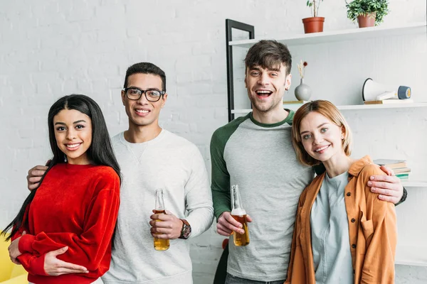 Smiling multicultural friends standing together and smiling at camera — Stock Photo