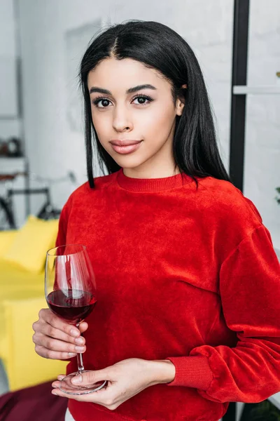 Bella ragazza afro-americana in possesso di un bicchiere di vino e guardando la fotocamera — Foto stock