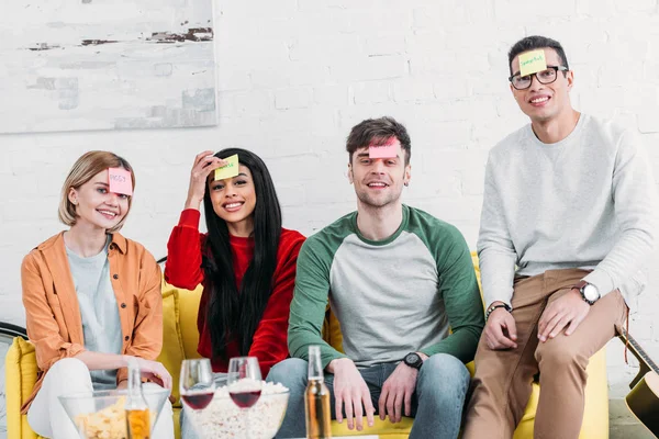 Happy multicultural friends with funny nickname labels on foreheads — Stock Photo