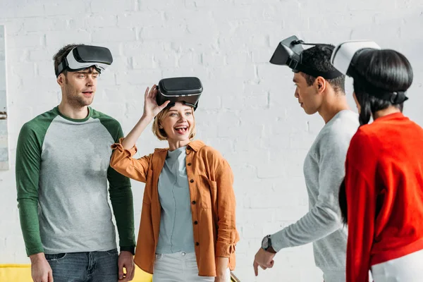 Amigos multiétnicos colocando em fones de ouvido realidade virtual — Fotografia de Stock