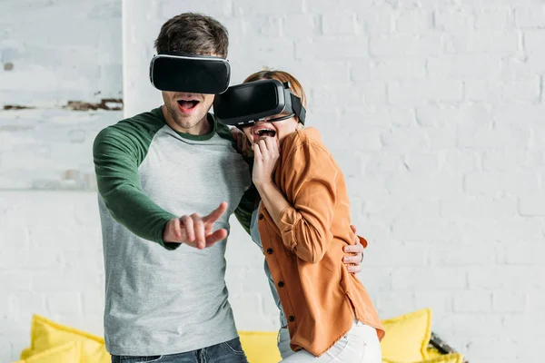 Amis excités réagissant émotionnellement tout en utilisant des casques de réalité virtuelle — Photo de stock