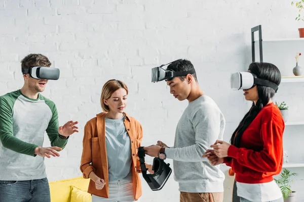 Amigos multiétnicos colocando em fones de ouvido realidade virtual — Fotografia de Stock