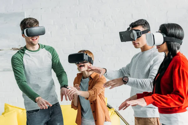 Amigos multiculturales divertirse mediante el uso de auriculares de realidad virtual en casa - foto de stock
