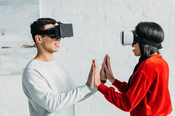 Interracial couple having fun by using virtual reality headsets — Stock Photo