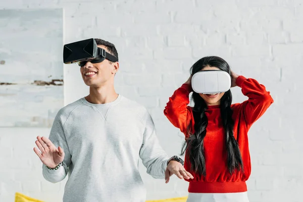 Pareja interracial divertirse mediante el uso de auriculares de realidad virtual - foto de stock