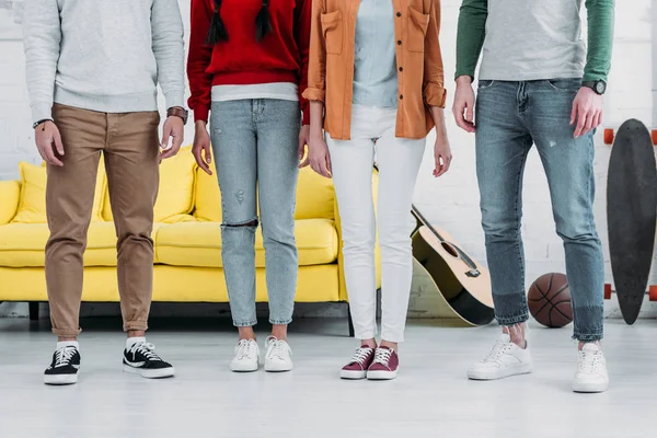 Partial view of friends standing together in living room — Stock Photo