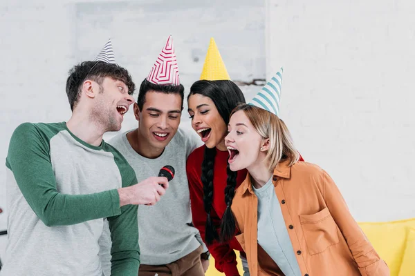 Multiethnic having fun at home party while singing karaoke — Stock Photo