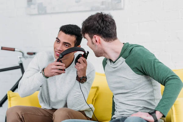 Amigos multiculturais se divertindo enquanto ouve música com fones de ouvido — Fotografia de Stock