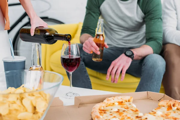 Cropped view of man and woman near table with drinks and snacks — Stock Photo