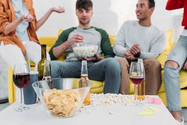 Multicultural friends having fun end enjoying snacks and drinks at home party — Stock Photo