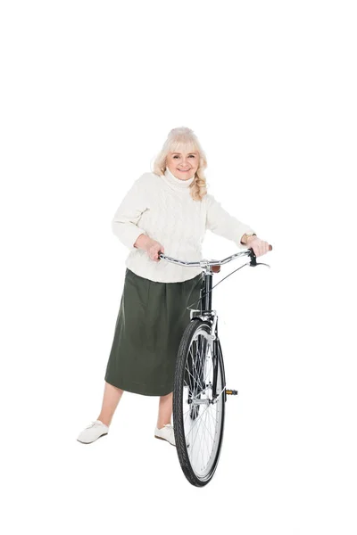 Femme âgée souriante debout avec vélo isolé sur blanc — Photo de stock