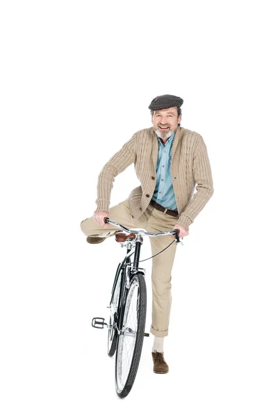 Alegre pensionista sonriendo mientras monta en bicicleta aislado en blanco - foto de stock
