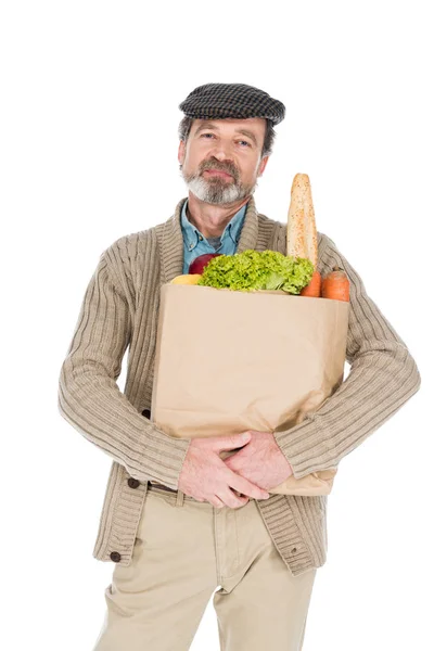 Fröhlicher älterer Mann hält Papiertüte mit Lebensmitteln auf weißem Grund — Stockfoto