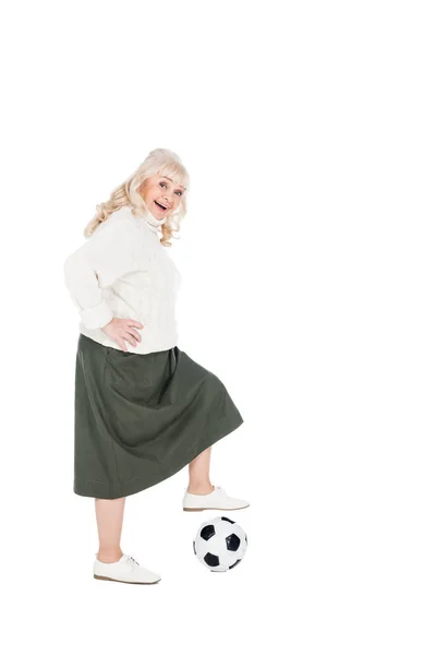 Smiling senior woman playing football isolated on white — Stock Photo