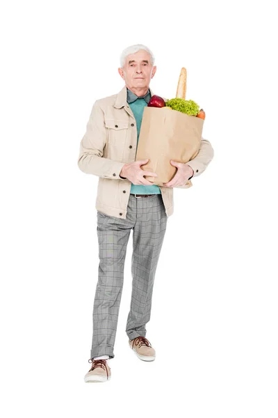 Hombre retirado sosteniendo bolsa de papel con productos aislados en blanco - foto de stock