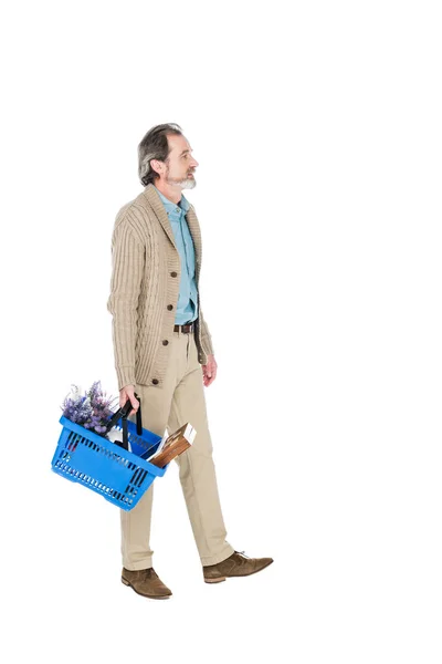 Веселий чоловік на пенсії, що йде з кошиком для покупок ізольовано на білому — стокове фото